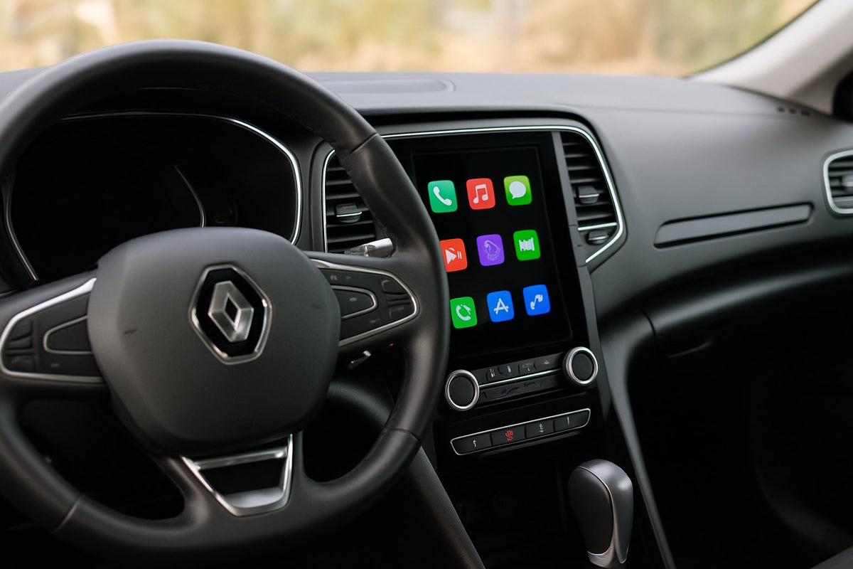 Renault Mégane 4 équipée d'un grand écran CarPlay vertical intégré à la console, vue depuis le siège conducteur avec le losange Renault au volant